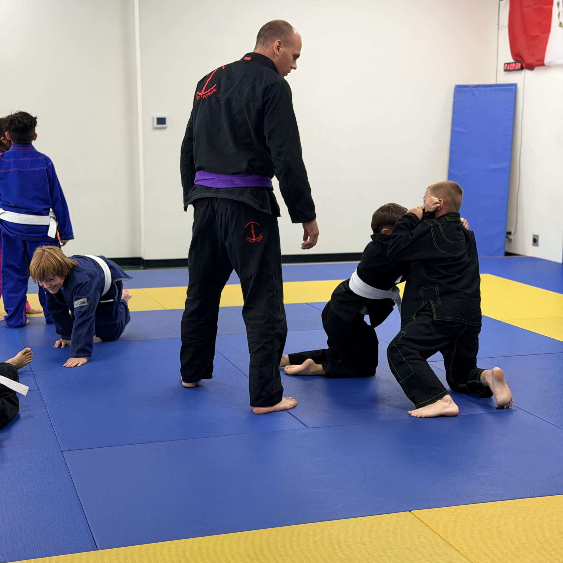 coach jordan teaching kids jiu jitsu class grappling